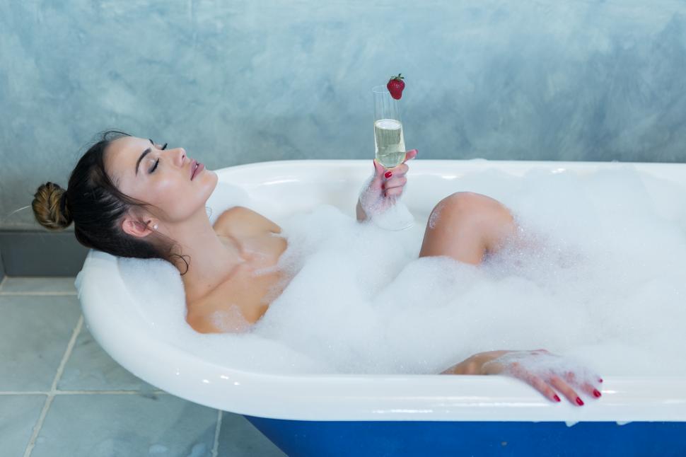 Free Image of Beautiful lady with champagne enjoying foamy bath 