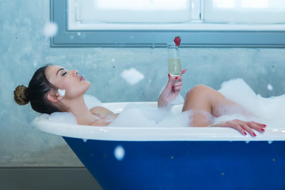 Download Free Stock Photo of Woman with champagne relaxing in foamy bathtub 