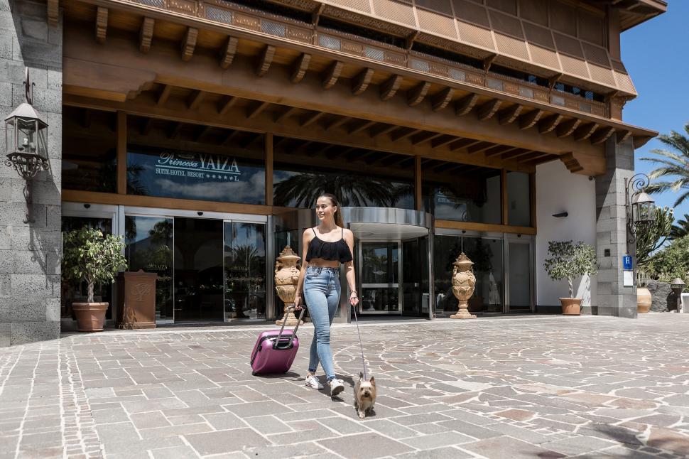 Free Image of Tourist with dog leaving hotel 