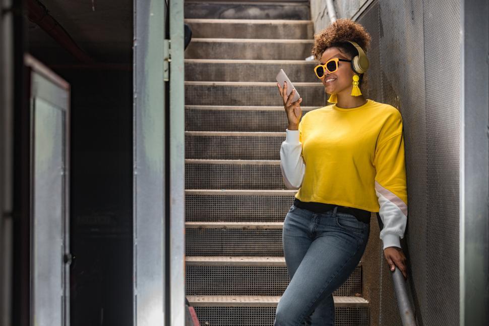 Free Image of Positive black hipster woman in trendy outfit using mobile phone 