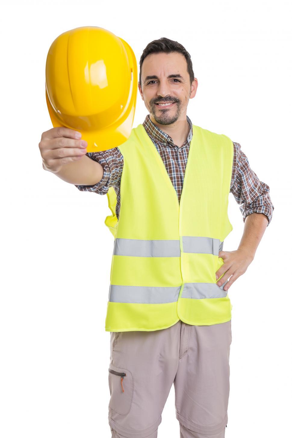 Free Image of Male supervisor in uniform showing hardhat at camera 
