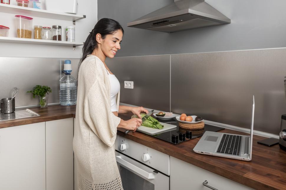 Free Image of Woman watching video and cooking at home 
