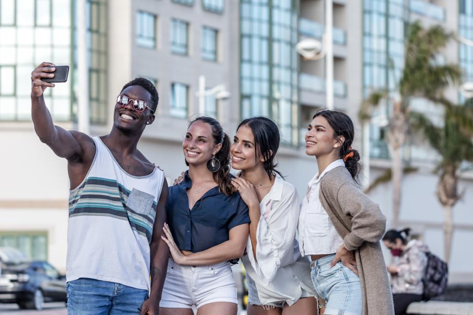 Free Image of Company of cheerful diverse friends taking selfie in city 