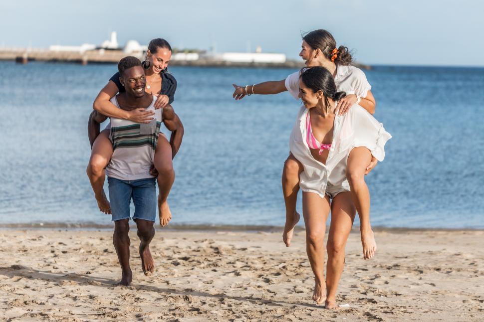 Free Image of Multiracial friends having fun on beach together 
