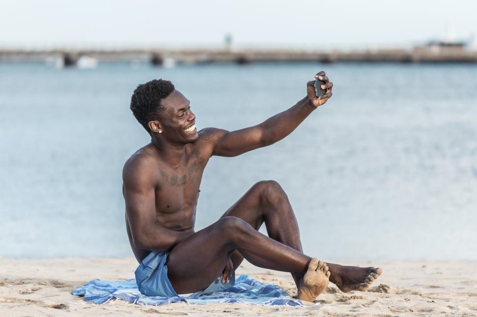 Free Image of Delighted man taking selfie on beach 