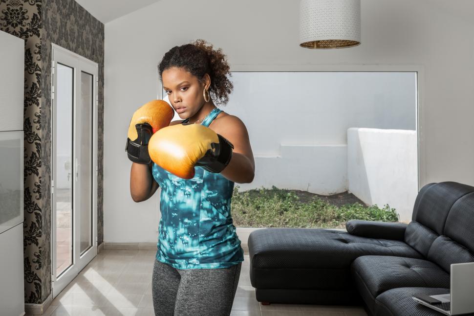 Free Image of Confident ethnic woman in boxing gloves during workout at home 