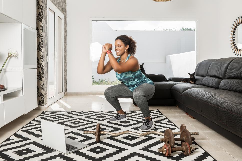 Free Image of Delighted woman doing squats during training at home 