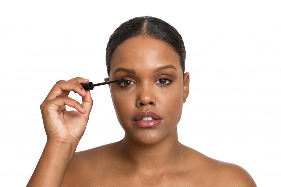 Free Image of Black woman applying mascara on eyelashes 