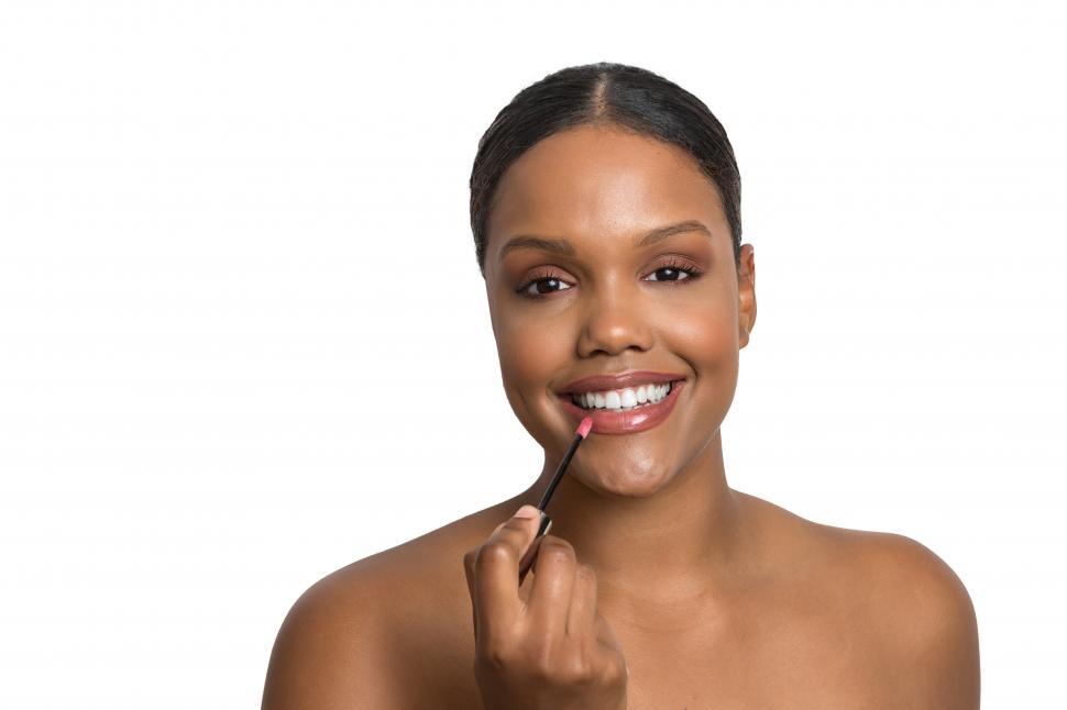 Free Image of Smiling African American woman applying lipstick 