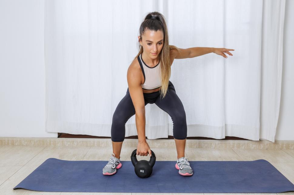 Free Image of Active woman lifting kettlebell during workout 