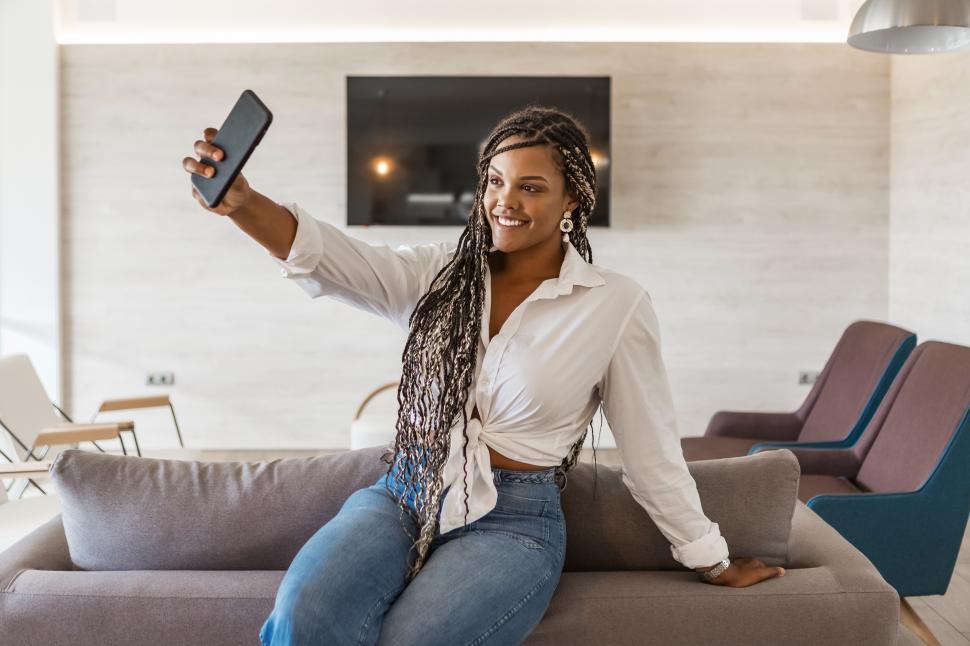 Download Free Stock Photo of Cheerful woman in her home using phone to take a selfie 