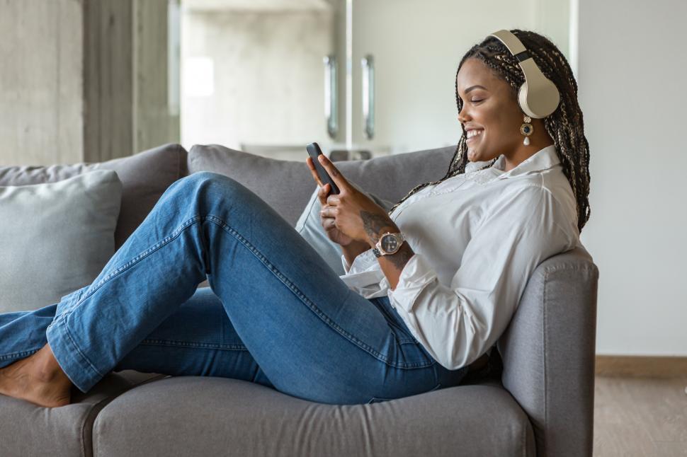 Download Free Stock Photo of Happy young woman listening to music with headphones 