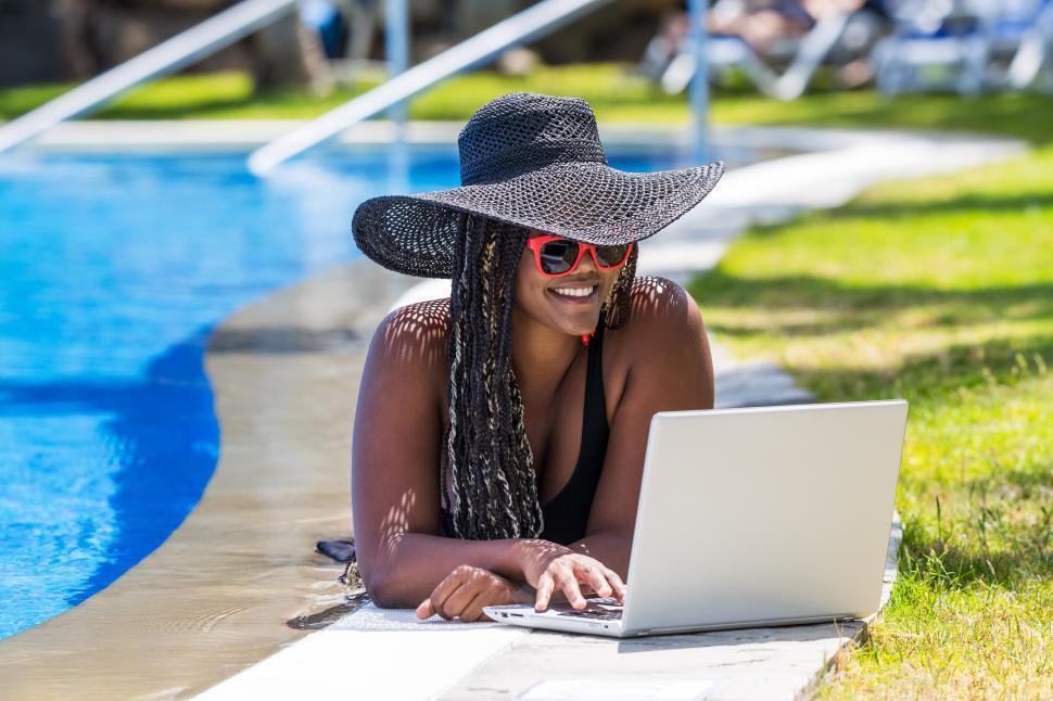 Download Free Stock Photo of Woman lying on the edge of the pool with a laptop 