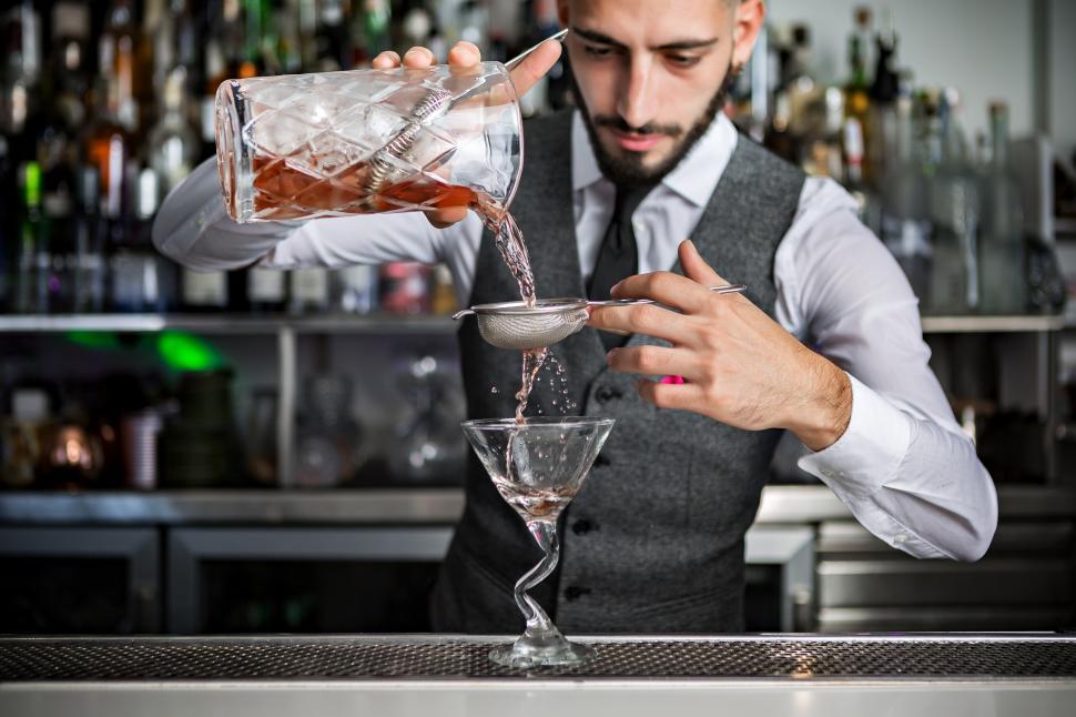 Free Image of Barman pouring cocktail into glass 