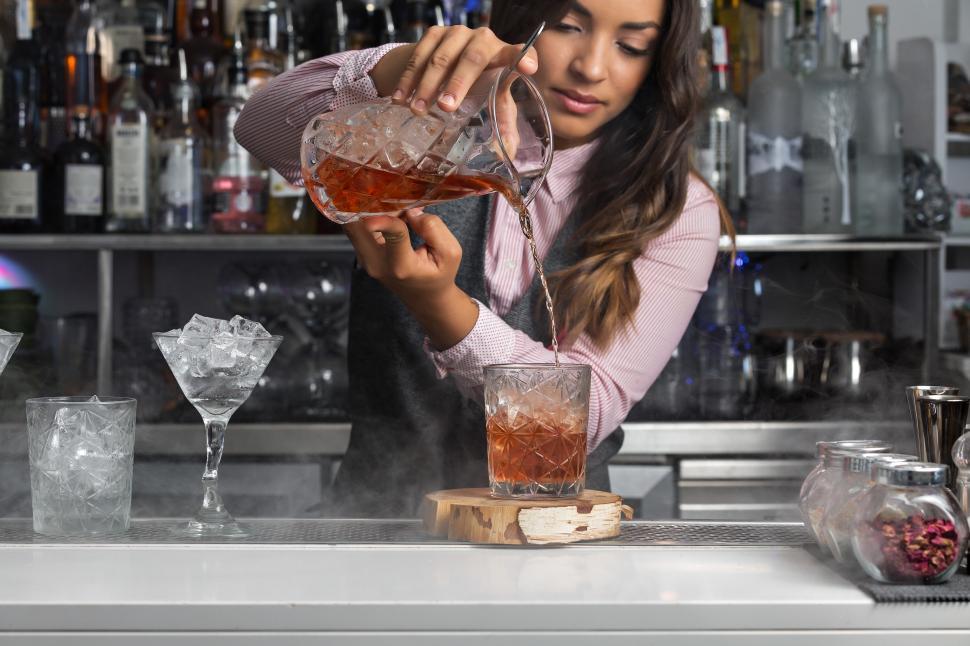 Free Image of Woman preparing cocktail at bar counter 