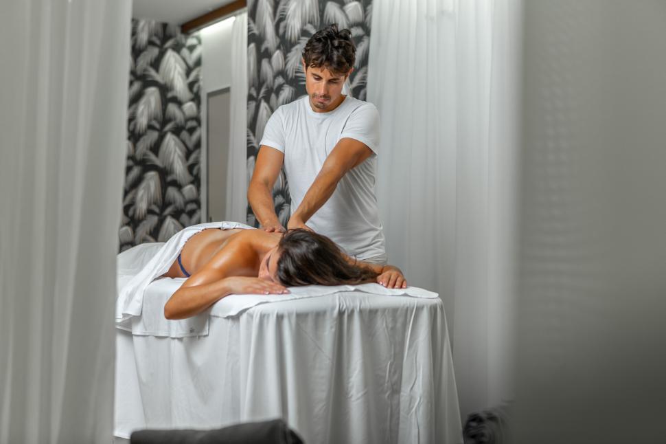 Download Free Stock Photo of Masseur doing a back massage to a relaxed woman 
