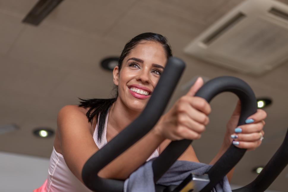 Free Image of Low angle view of a woman doing exercise in stationary bike 