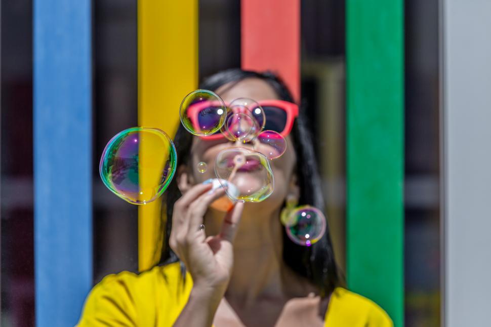 Free Image of Close up of a young adult woman blowing bubbles 