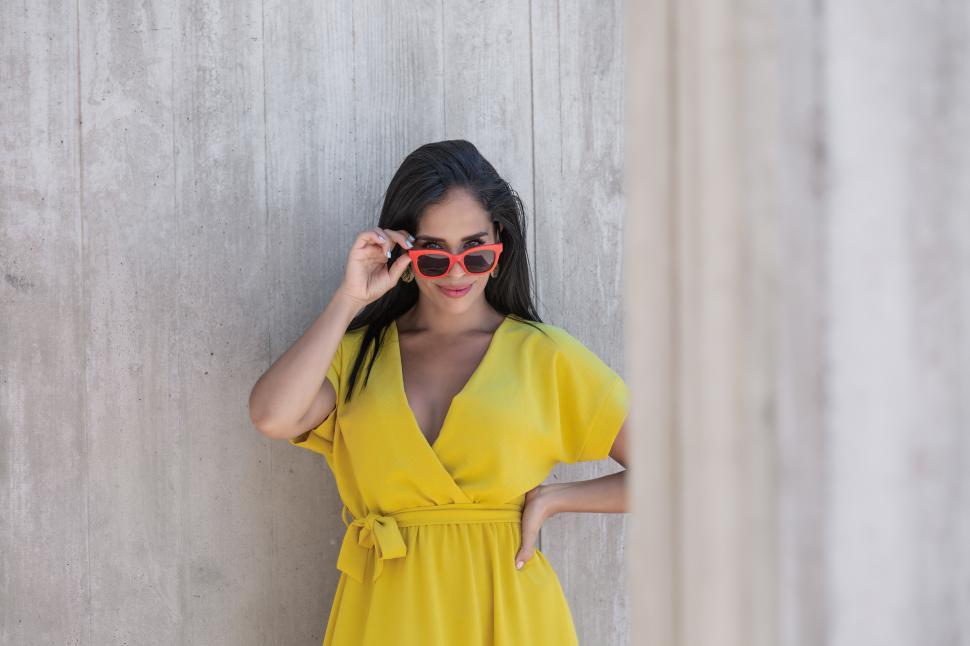 Free Image of View young Latina woman in yellow dress wearing sunglasses 