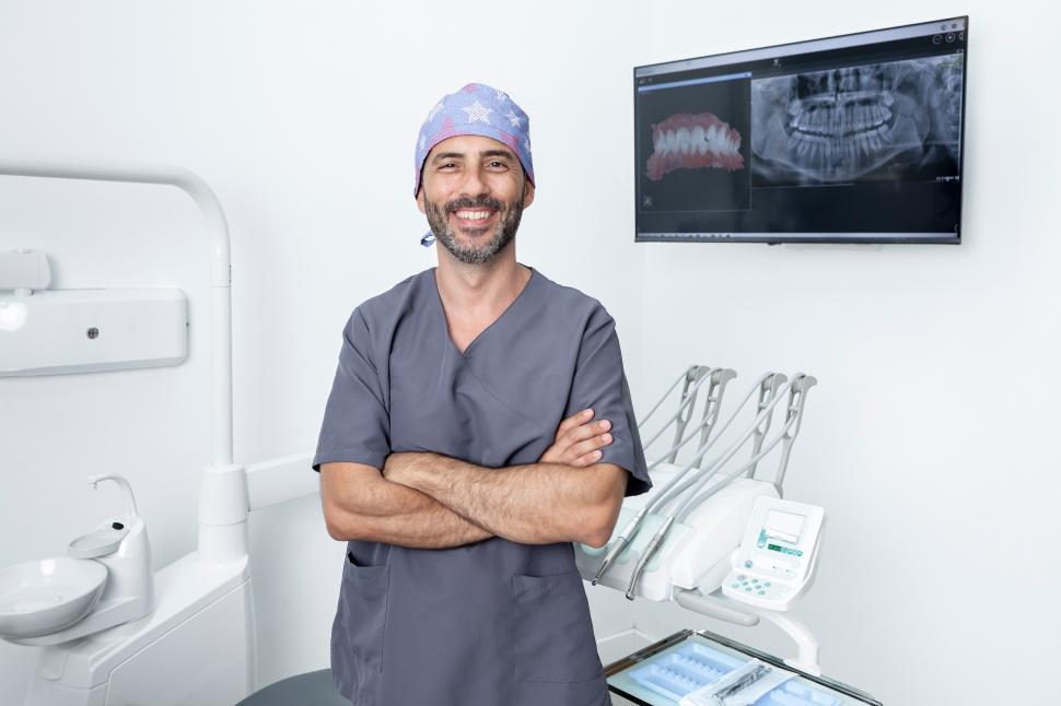 Free Image of Portrait of a dentist standing with arms crossed in a clinic 