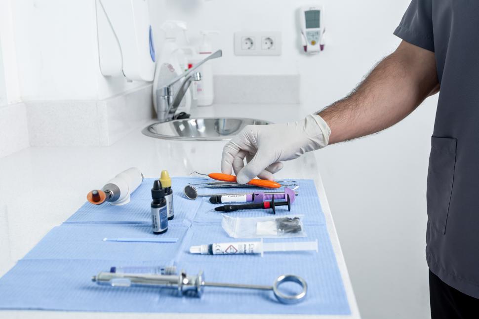 Free Image of Person taking a instrument from a table with sterile tools for a 