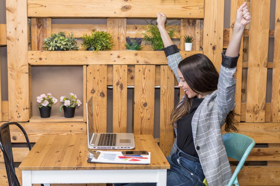 Download Free Stock Photo of Happy woman with raised fists during remote job 