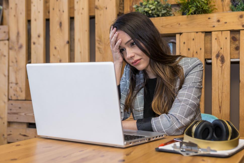 Download Free Stock Photo of Tired freelancer reading bad report on laptop during online work 