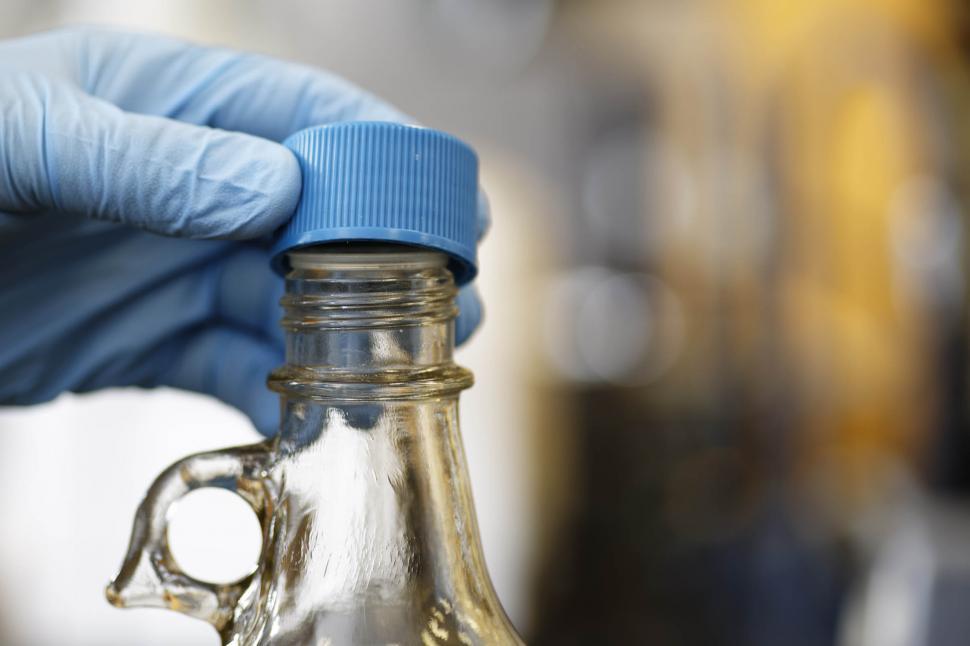 Free Image of Fingers removing cap from chemical bottle 