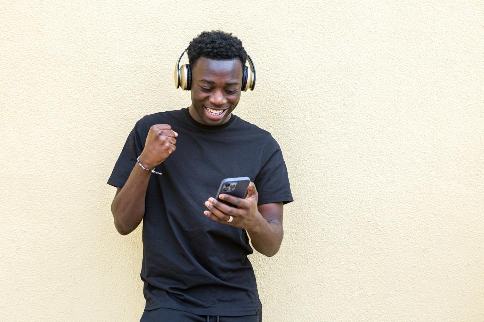 Free Image of Joyful young black guy clenching fist and smiling 