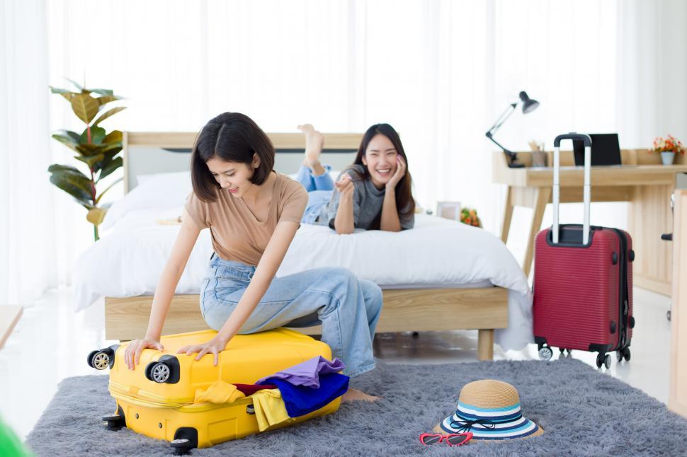 Free Image of Young woman preparing travel suitcase. 