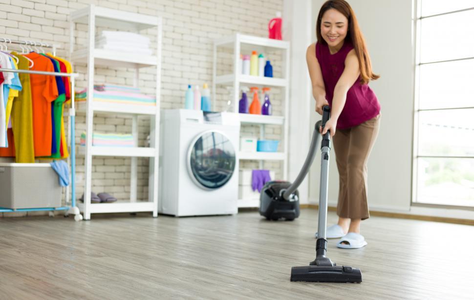 Free Image of Woman vacuuming the floor 