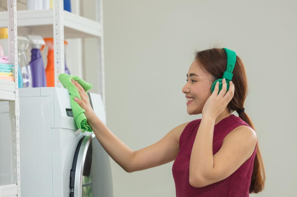 Free Image of Young woman is wiping the washing machine 
