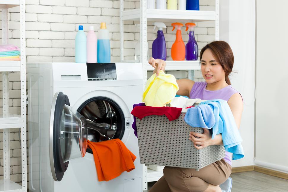Free Image of Asian woman doing laundry with washing machine 