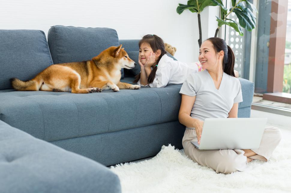Free Image of Adorable mother and daughter are sitting with the dog 