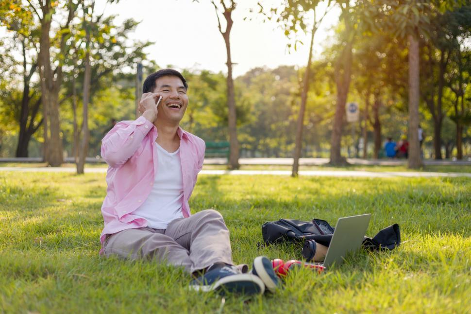 Free Image of Happy Asian man talking on the phone 