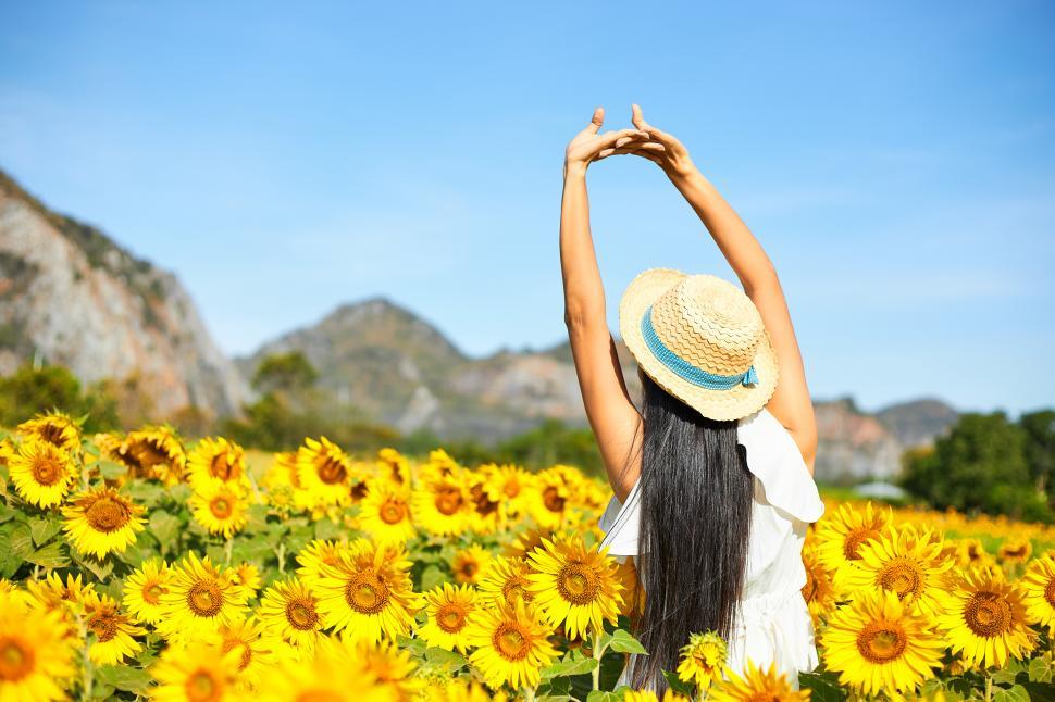 Free Image of Woman relaxing in a sunflower field 