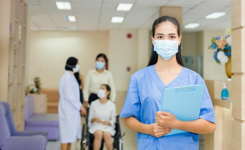 Download Free Stock Photo of Doctor wearing a mask holding a file in the hospital 