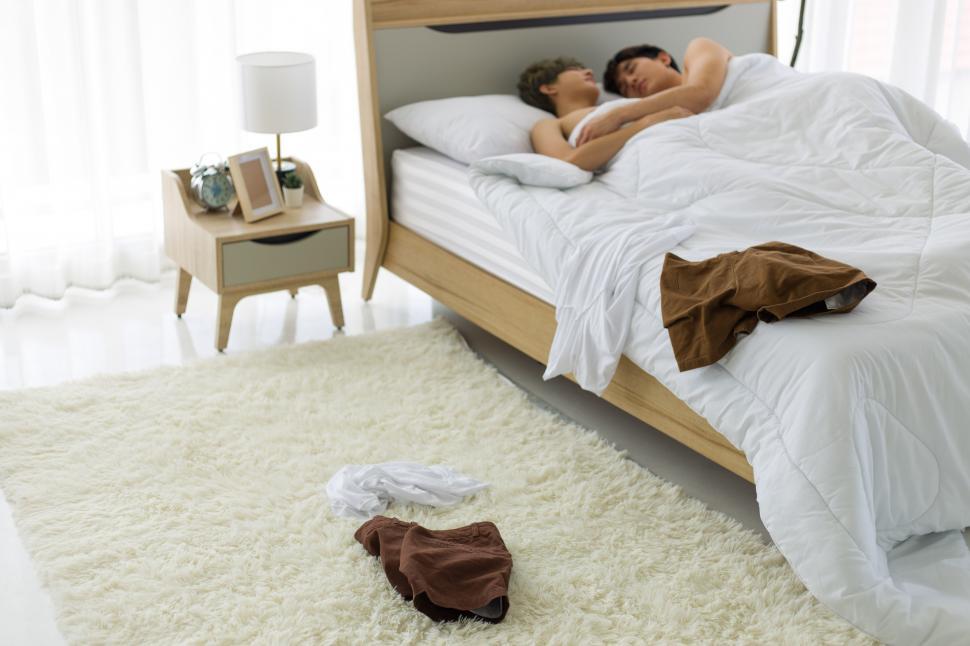 Free Image of Gay couple lying on white bed. 