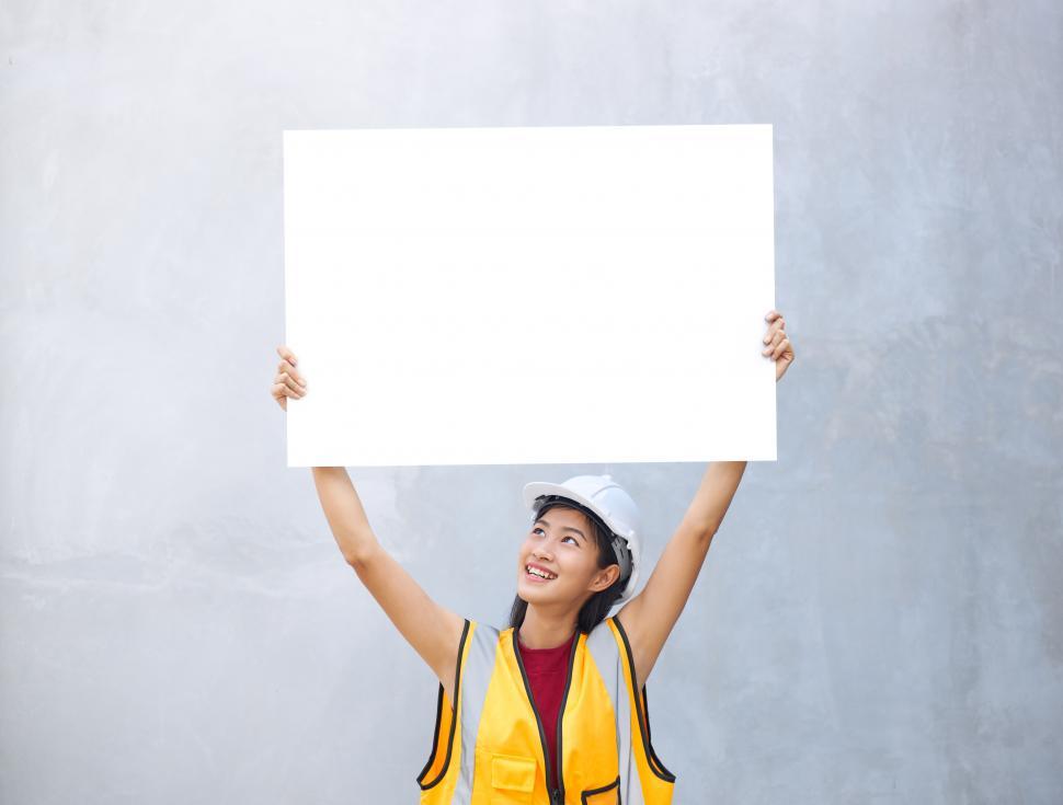 Download Free Stock Photo of A female engineer holding a paper placard with empty space with 