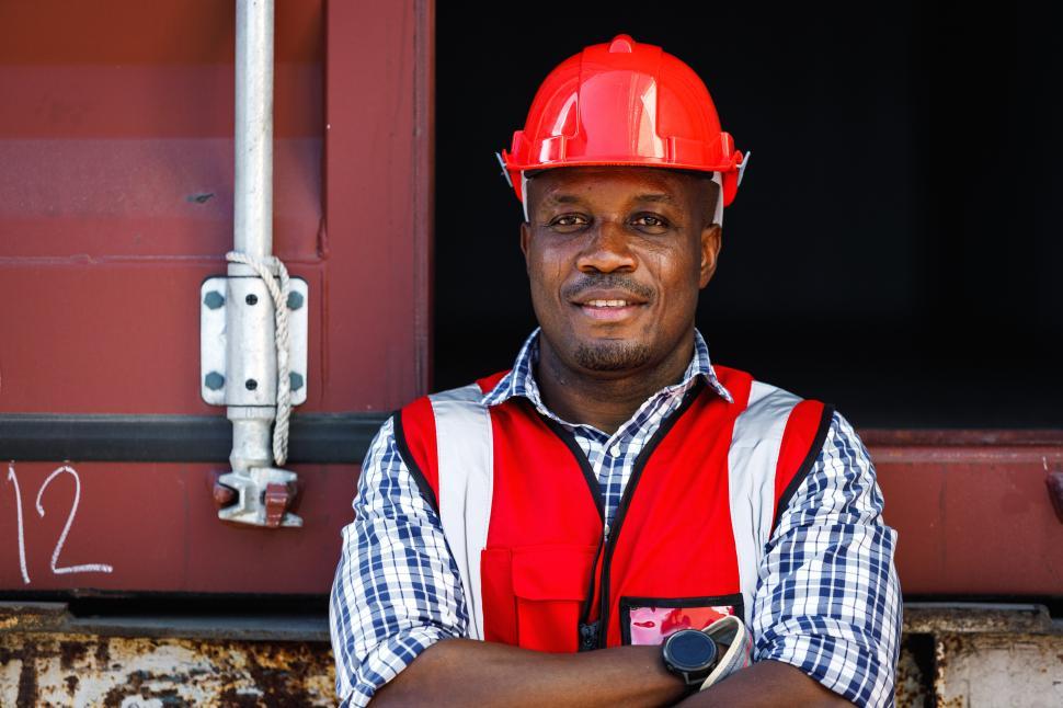 Download Free Stock Photo of Industrial worker in protective clothing stands with arms crossed 