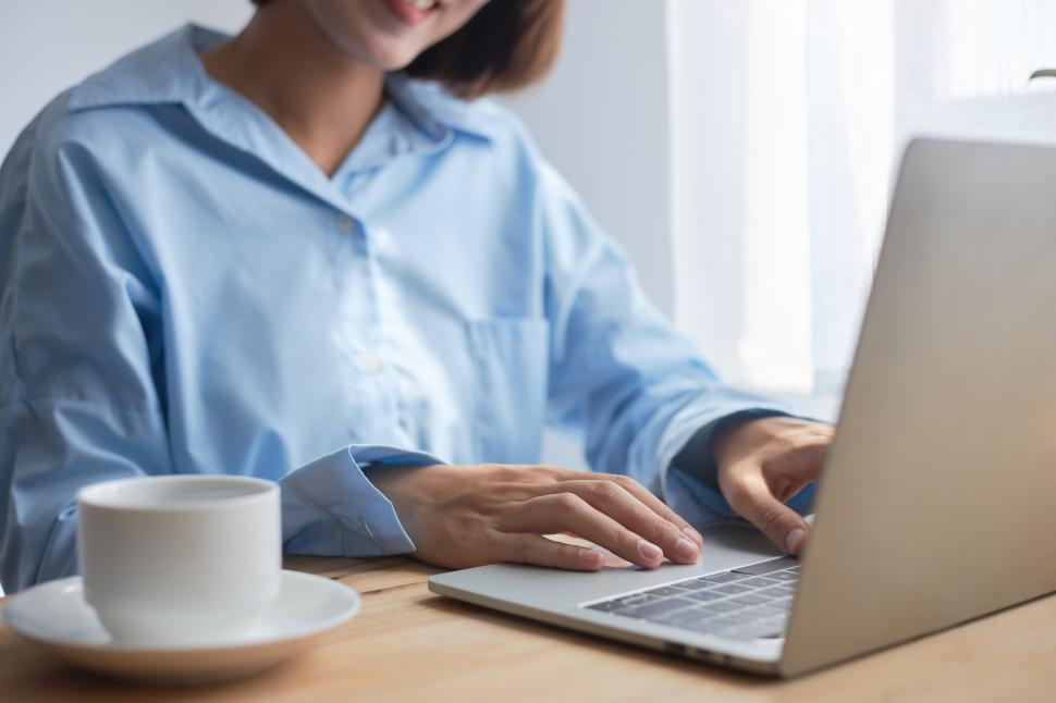 Free Image of A woman working on a laptop in the morning at home. 