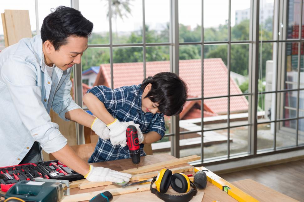 Free Image of Father teaches his son to do carpentry at home 