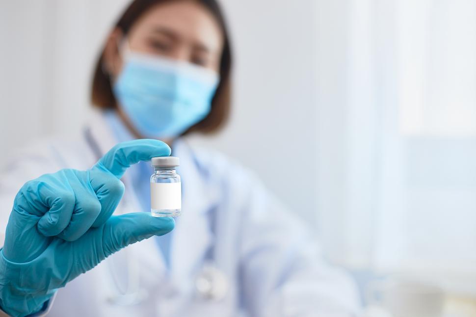 Free Image of A researcher or a doctor holding a vaccine bottle. 