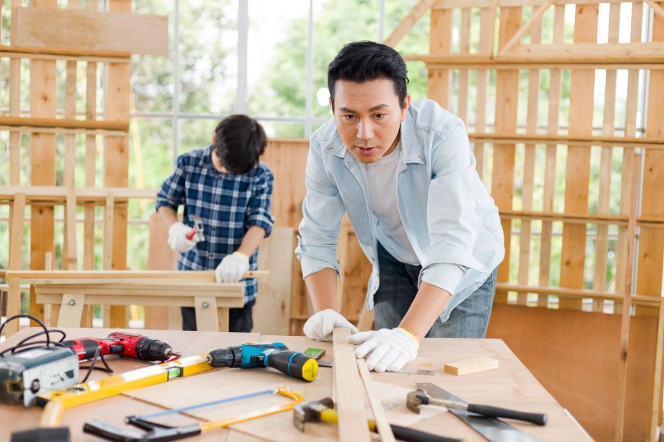 Free Image of Father practices woodwork while his son helps nearby. 