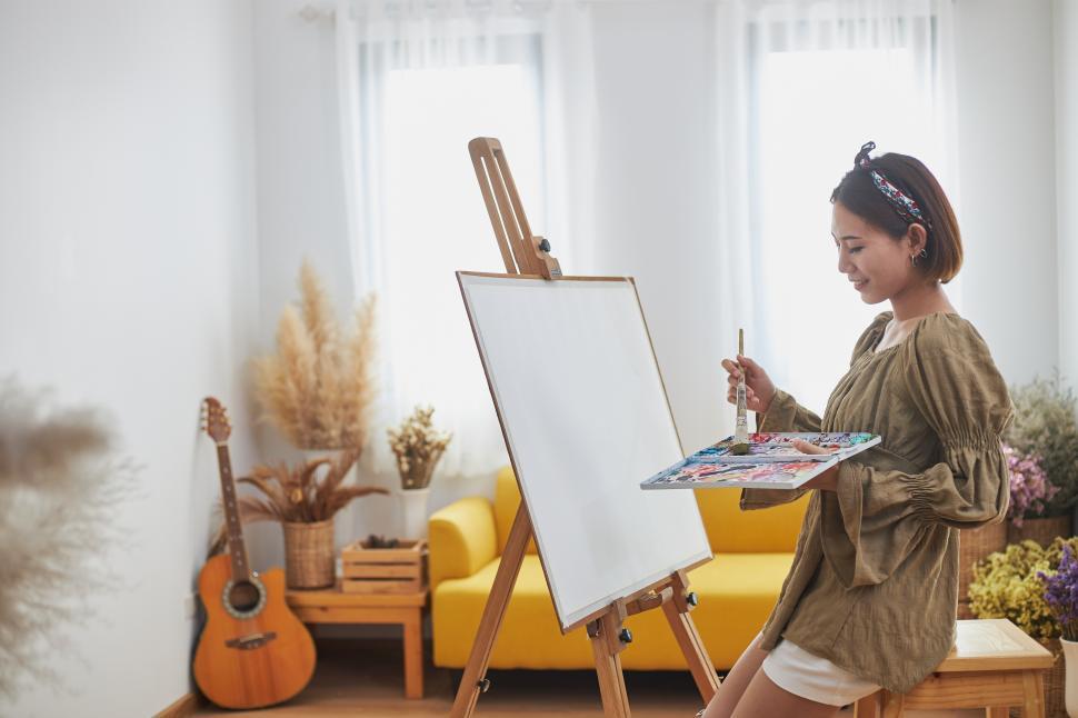 Free Image of Artist is painting at her easel 