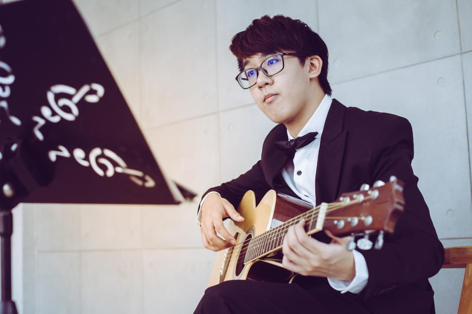 Free Image of Young man playing acoustic guitar 
