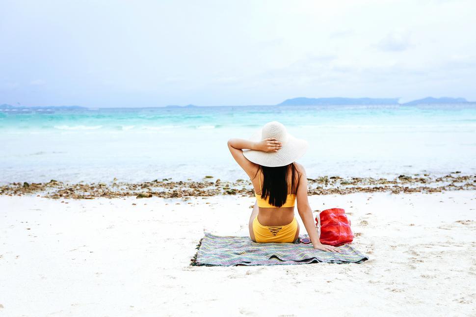 Free Image of Woman with yellow bikini relaxing on the beach 