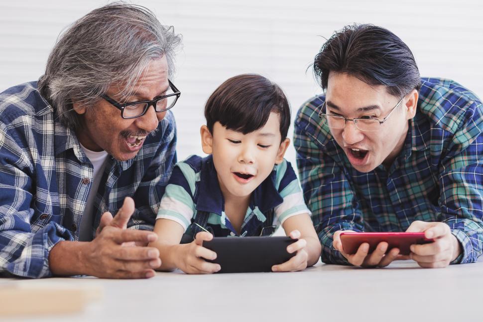 Free Image of Three generations are amazed by video on a phone 