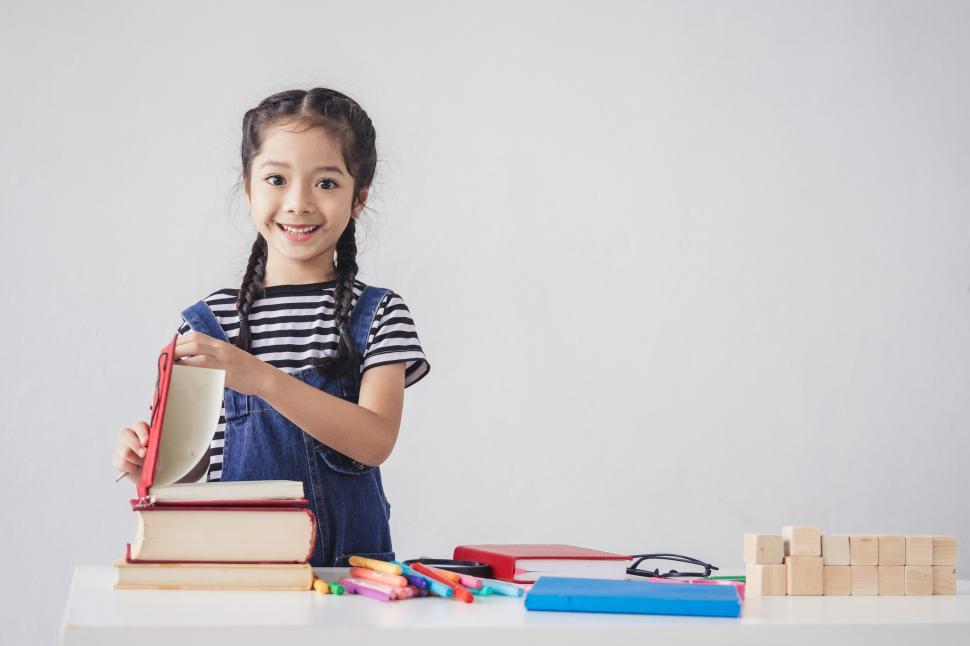 Free Image of Little girl is happy with school supplies 