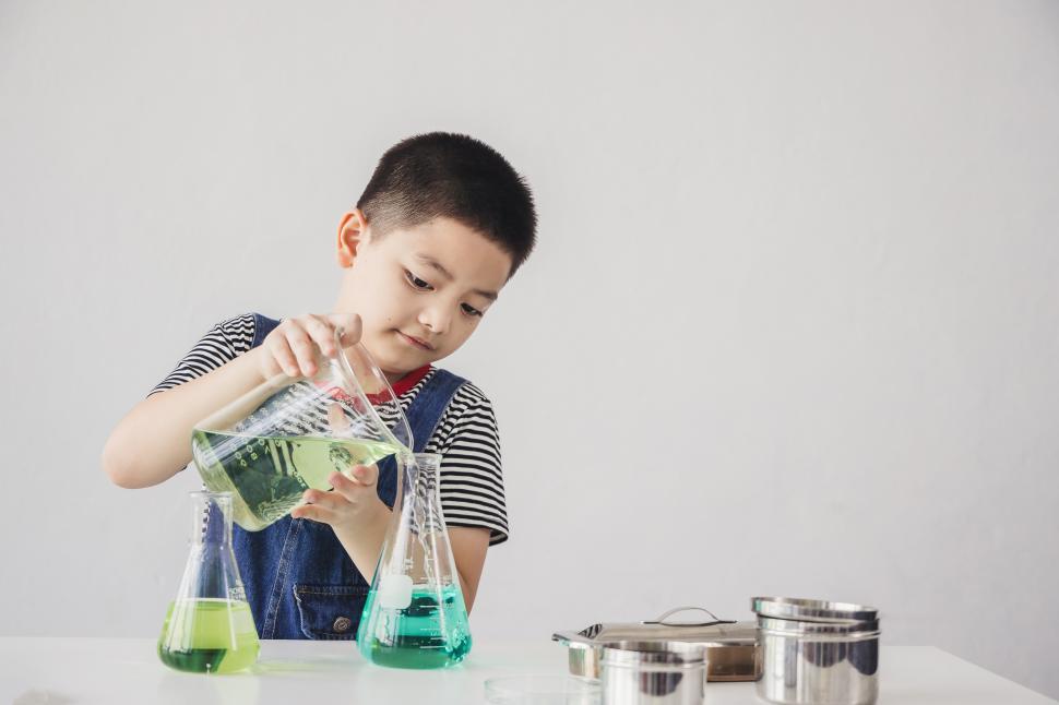 Free Image of Educational concepts - Little boy poured water in flask. 